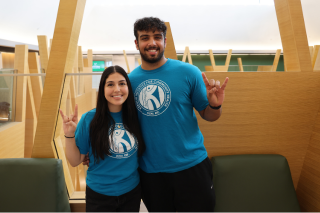 Judy Genshaft Honors College students Nusheen Immen and Aakash Vijeesh pose for a photo while making "Go Bulls" hand signs