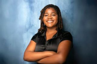 Judy Genshaft Honors College student Chinaza Munonye headshot against a blurred blue background