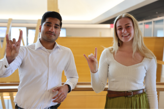 St. Petersburg Judy Genshaft Honors College Students Abdul Muqeet Khawaja and Taylor Herman pose while making a Go Bulls sign