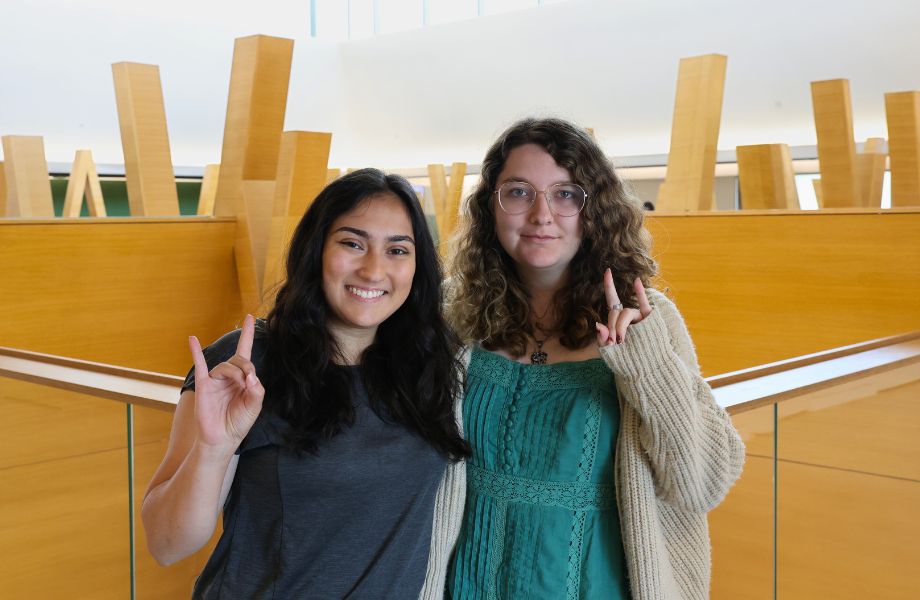 Maria Isaacs and Reva Ghandi pose with the "Go Bulls" hand sign on the fifth floor of the Honors building.