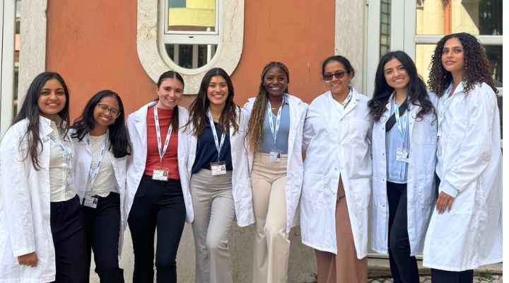 A group of Honors students pose in their white coats in Portugal.
