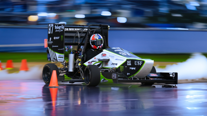 Bulls Racing car zooms down a race track.