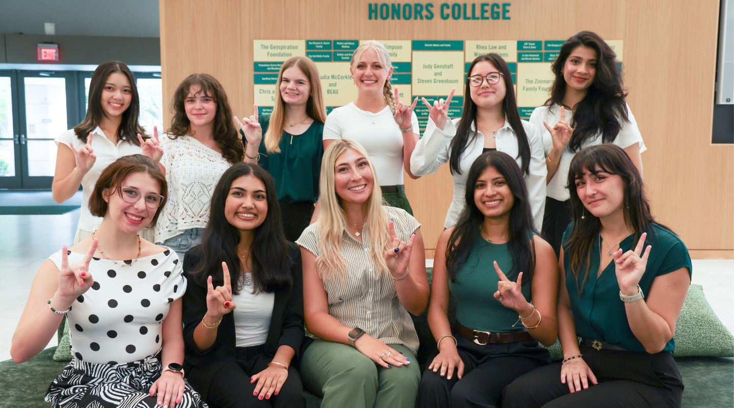Tampa Student council members and graduate assistant Tina Thai pose seated and standing in the Honors atrium