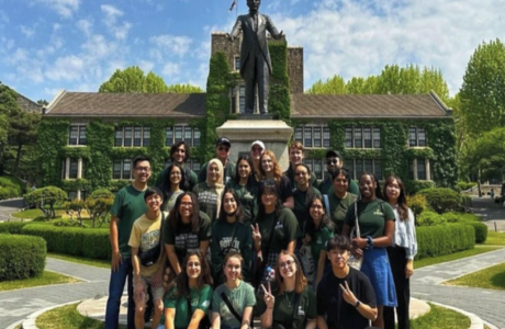 South Korea beyond the classroom students smile in front of a historical statue.