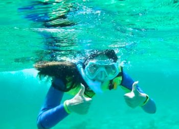 Image of student giving a thumbs-up while snorkeling linking to the Bahamas: Exploring Tropical Environments by Land and Sea study abroad program webpage..