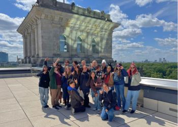 Image of Judy Genshaft Honors College students posing while making Go Bulls signs linking to the Germany Beyond the Classroom study abroad program webpage.