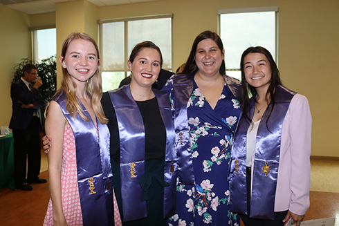 Four people smile at the camera at the 2022 Phi Beta Kappa Inauguration Ceremony