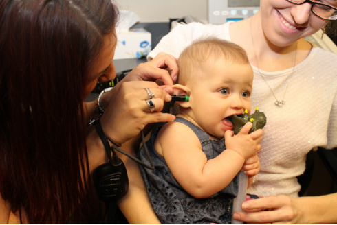 Ashley Hinton performs an ear exam on a small child. 