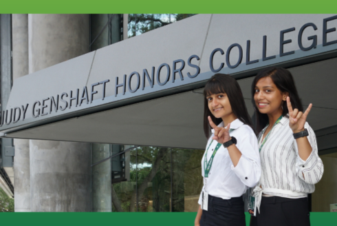 Two Indian female students standing in front of the Judy Genshaft Honors College building on the USF Tampa campus