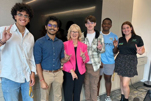 Dr. Susan MacManus smiles alongside a group of USF Honors students.