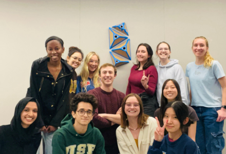 12 members of the USF 3D HAB-Lab smile and pose for a photo in the Judy Genshaft Honors College building