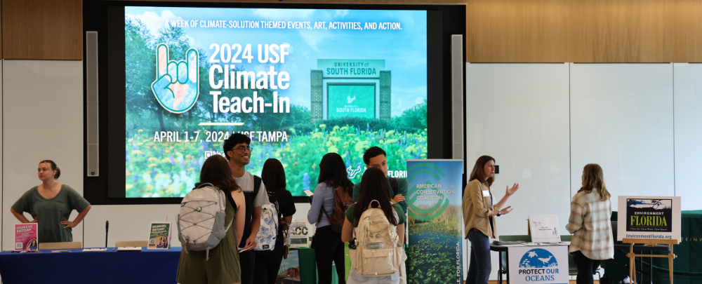 A small group of students talk with various community partners at the 2024 USF Climate Teach-In career and intership fair.