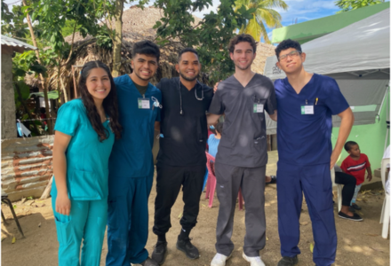 Honors students wearing scrubs smile in the Dominican Republic