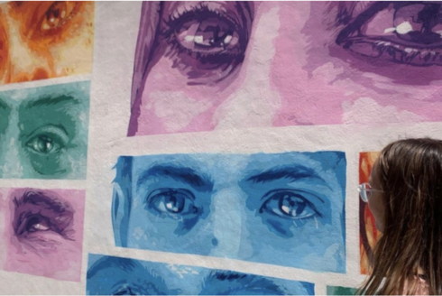Art exhibit featuring a mural of multiple eyes of different colors.