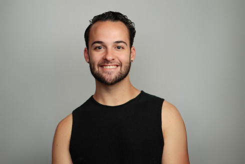 Headshot of Justin Haborak smiling with a gray background