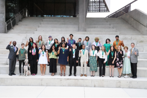 Honors College Spring 2024 Graduates smile for a group photo with Dr. Judy Genshaft and Steven Greenbaum.