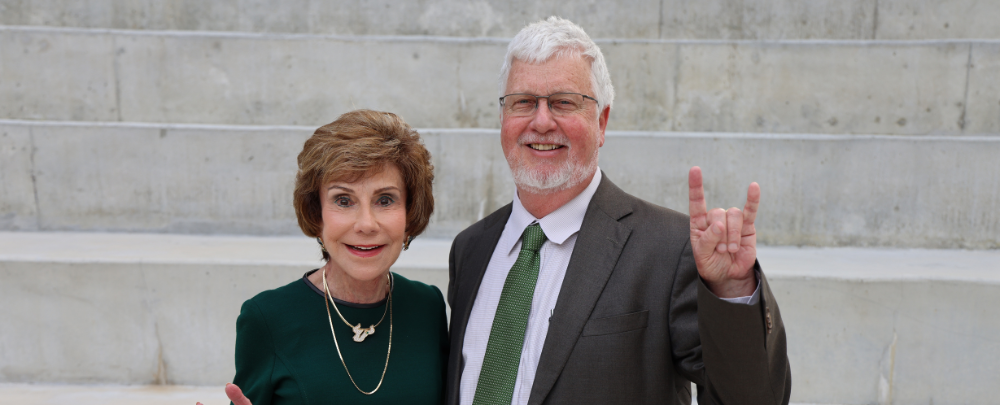 Dean Adams and President Emerita Genshaft smile in front of the Judy Genshaft Honors College