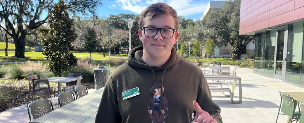 Student Mykyta Nechieva smiles in front of the Judy Genshaft Honors College