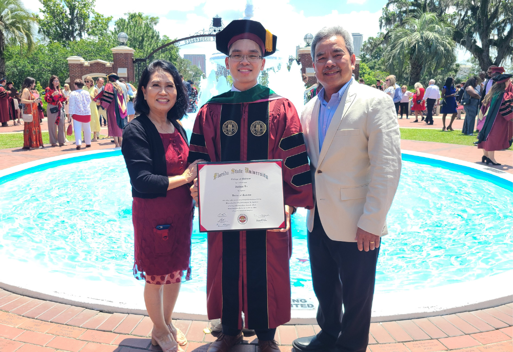 Nathan Le smiles with his parents at his graduation from FSU's College of Medicine