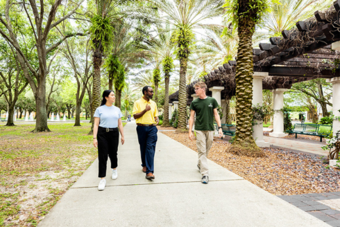 Students walk across USF's scenic campus with faculty member Dr. Lucien
