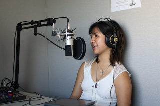 Judy Genshaft Honors College Student Sophia Montejo sits at a desk in front of a microphone while being interviewed for the Honor Roll Podcast