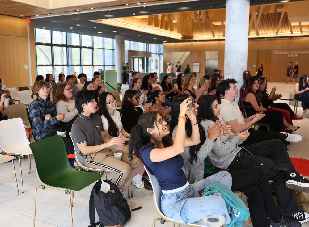 The Honors Got Talent audience enjoying the performance, filming and clapping.