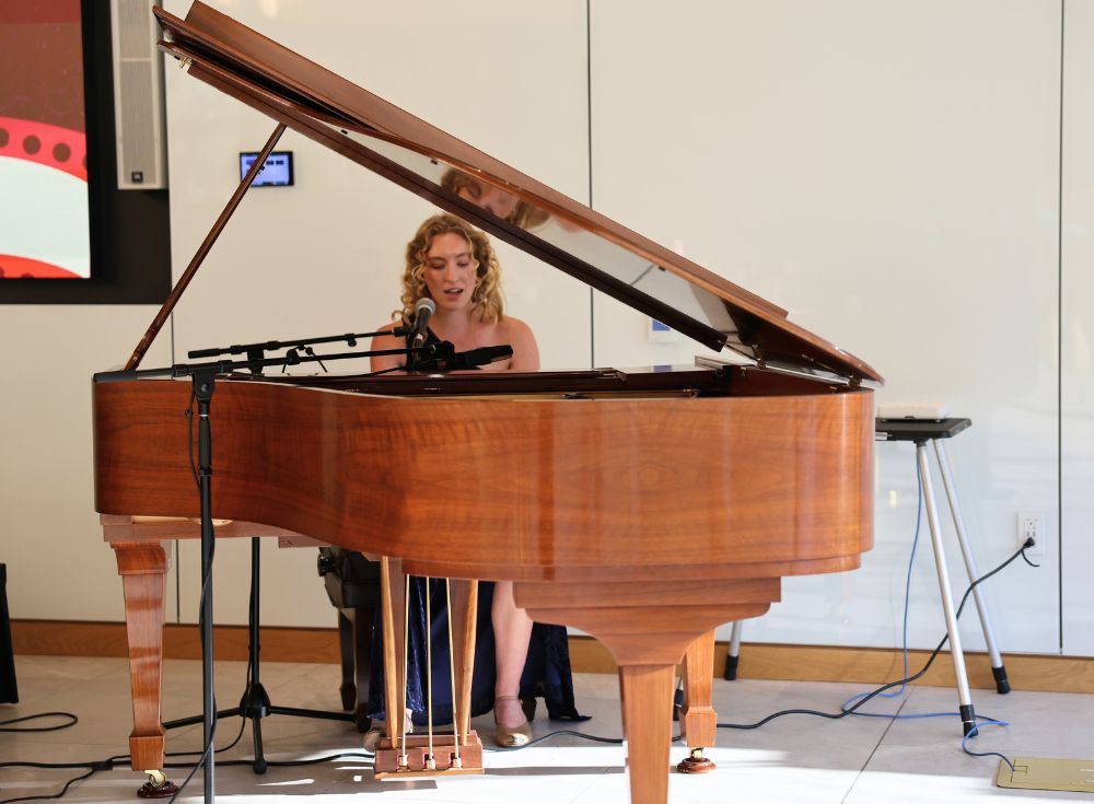 Performer Delaney Ross singing "Make You Feel My Love" by Bob Dylan while playing piano.