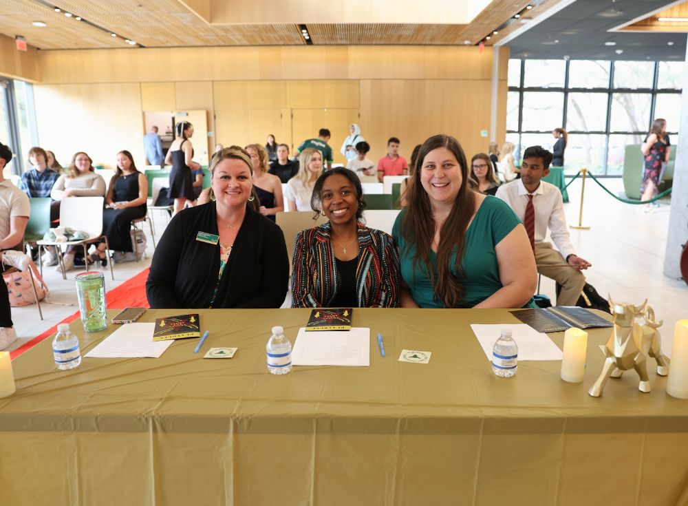 Lauren Chambers, Anrae Stephenson, and Megan Braunstein preparing their votes at one of the judges' tables. 