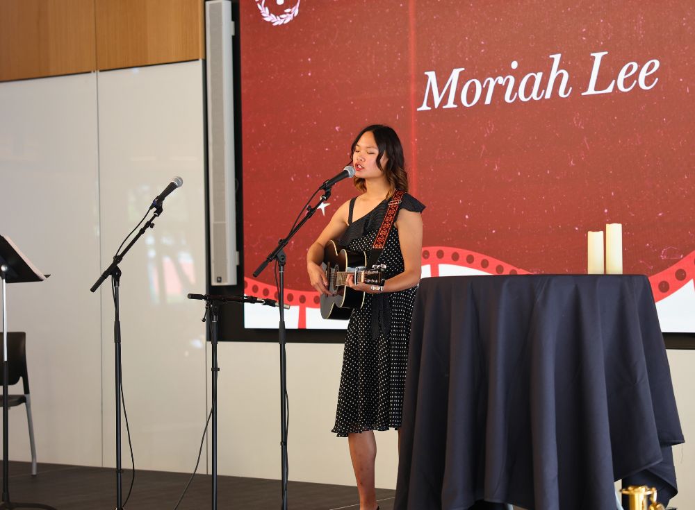 Moriah Lee, singing and playing an original song on the guitar.