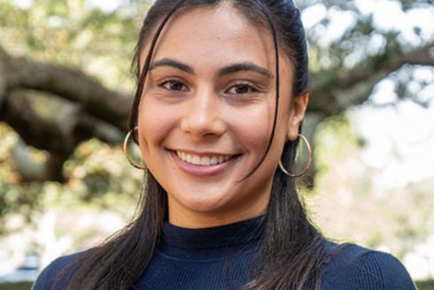 Alison Frate headshot outdoors, with a tree in the background