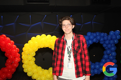 Anzhelika Kurnikova stands in front of Google logo made of small balloons.