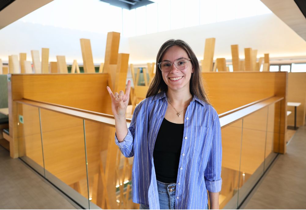 Brooke Casey holding up the Go Bulls handsign on the fifth floor of the Honors building.