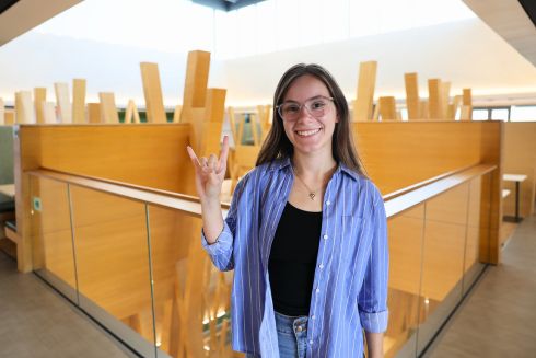 Brooke Casey holding up the Go Bulls handsign on the fifth floor of the Honors building.