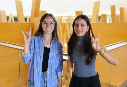 Brooke Casey and Fabiana Requena hold up the Go Bulls sign on the fifth floor of the Honors building.