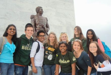 Bryce Montane poses with other Honors students in front of a monument.