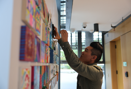 Dr. Andrew Hargrove hangs art for the Honors Climate Teach-in