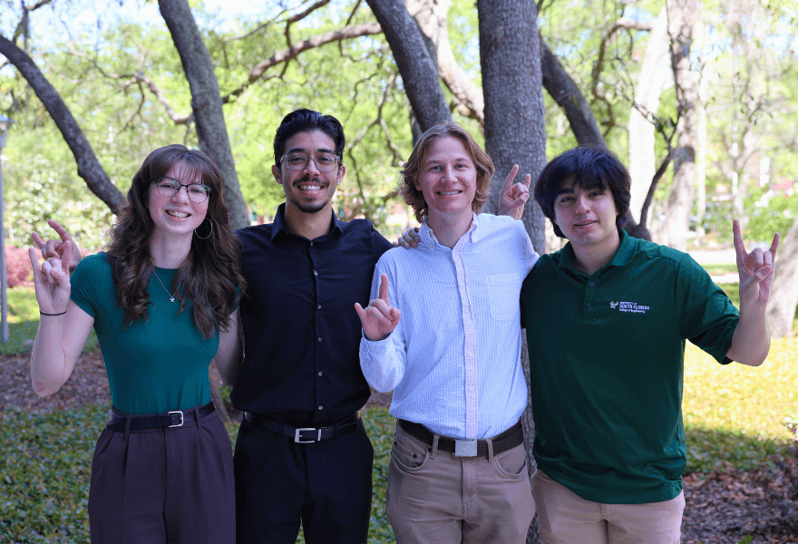 Goldwater scholars 2025 pose with the "Go Bulls" hand sign outside the Honors building