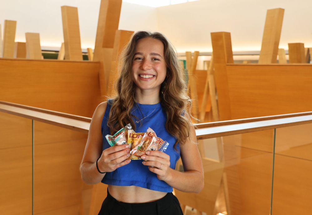 Mira Stimac, posing on the 5th floor of the Honors building with three flavors of her Lope Bars.