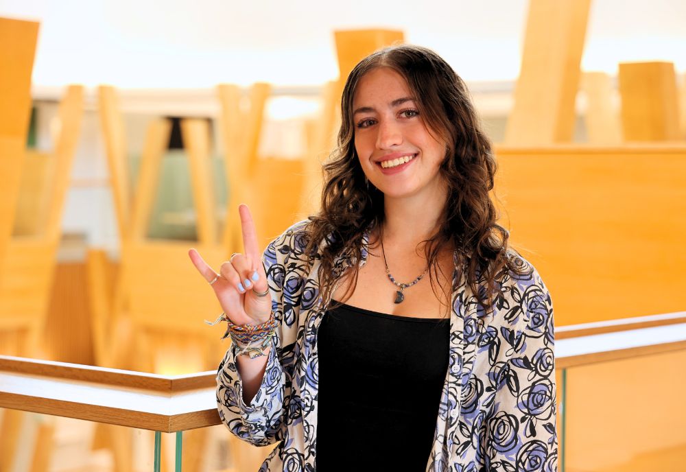 Natalie AmRhein poses with the "go bulls" hand sign on the fifth floor of the Honors building.