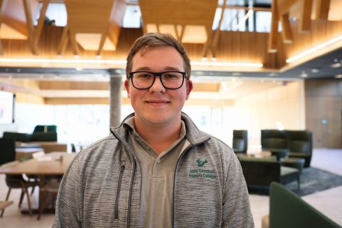 Judy Genshaft Honors College Student Council President Mykyta Nechaiev, smiling on the first floor of the Honors Atrium