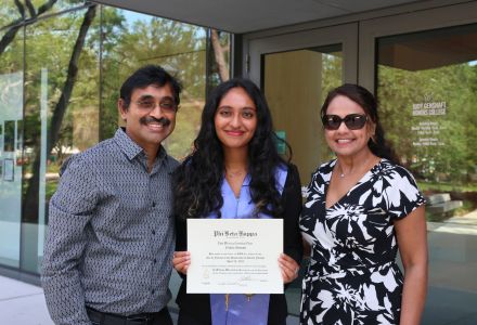 Phi Beta Kappa 2025 Inductees poses with her parents, while holding an induction certificate.