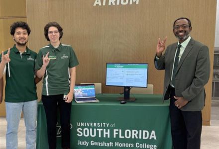 Honors It students and Dr. Reginald Lucien table in the Honors College.
