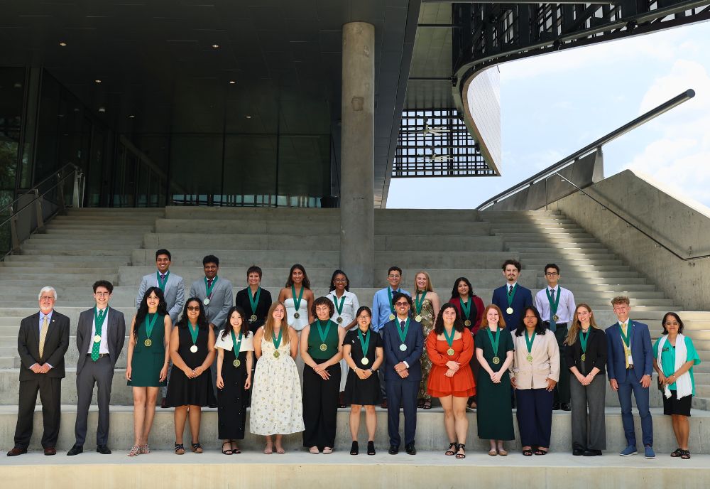 Summer graduates, Dean Adams, and Dean Sakai stand with their medallions on the Honors ampitheater steps