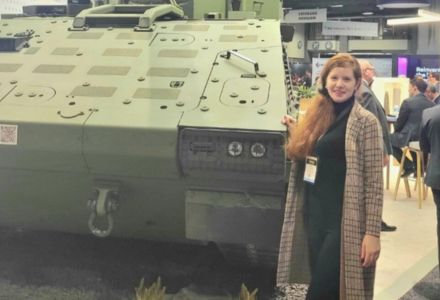 Zita Fletcher posing next to a war tank