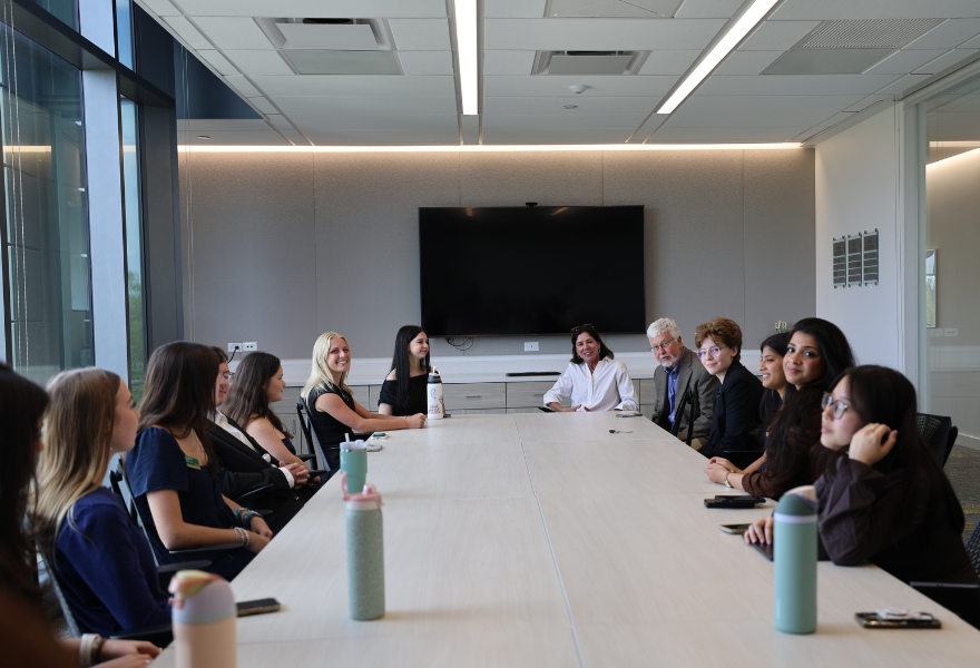 Student council and peer mentors sit at third-floor student leadership center conference table with Claudia McCorkle.