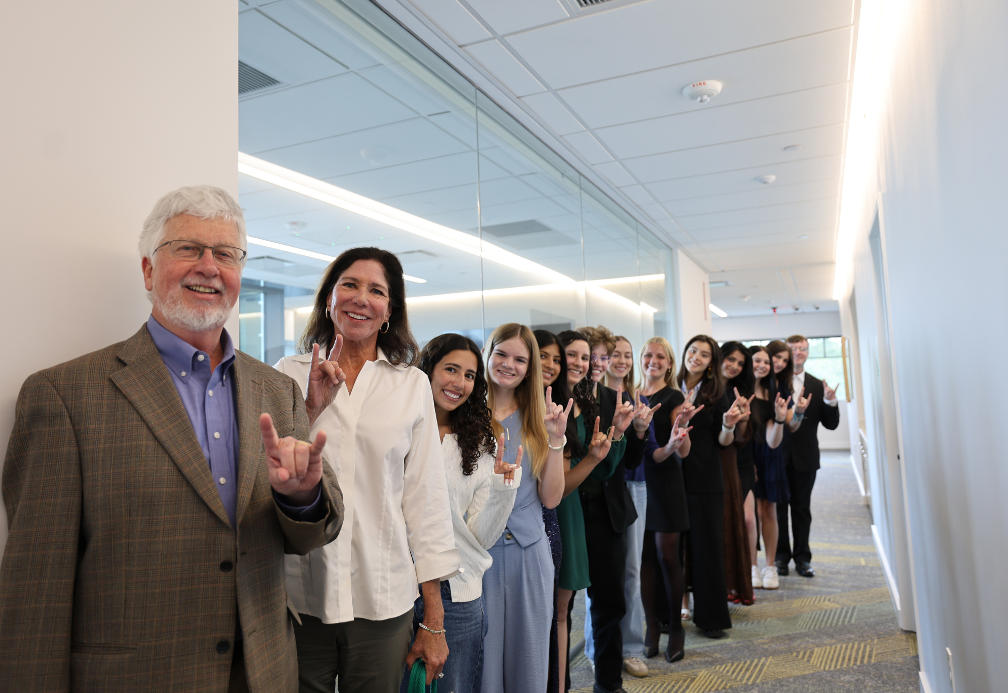 Judy Genshaft Honors College Dean Charles Adams and Claudia McCorkle stand with Honors peer mentors and student council members holding up the Bulls hand sign