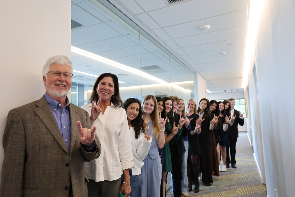 Judy Genshaft Honors College Dean Charles Adams and Claudia McCorkle stand with Honors peer mentors and student council members holding up the Bulls hand sign