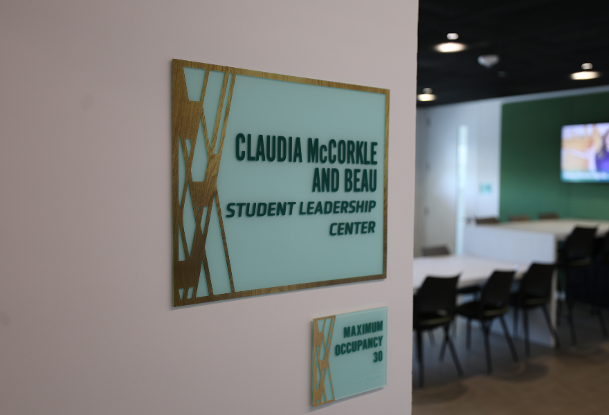 Claudia McCorkle and Beau Student Leadership Center plaque outside the conference room