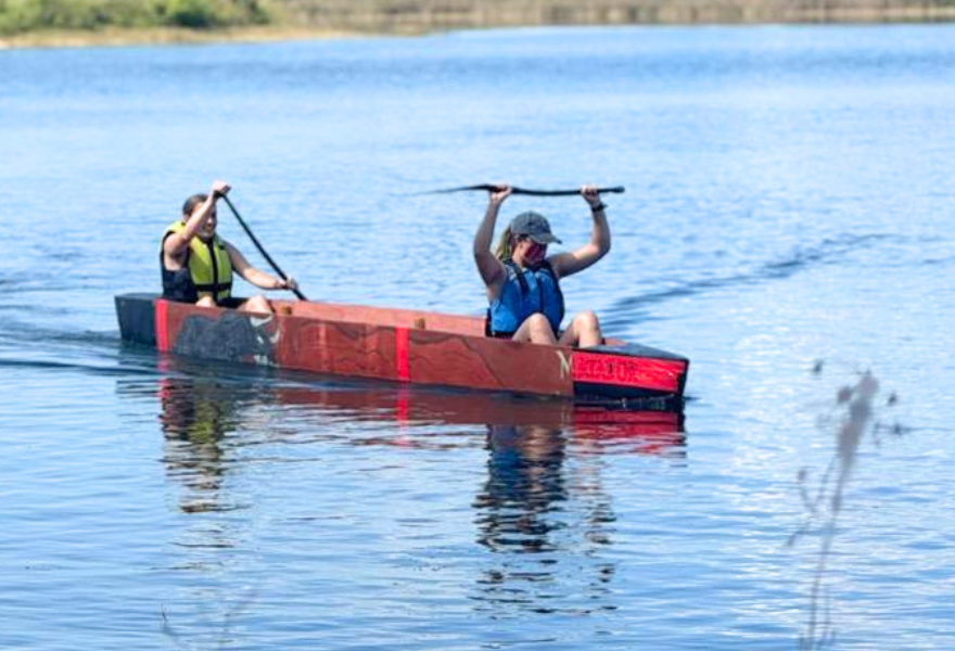 Two female students race canoe in the water