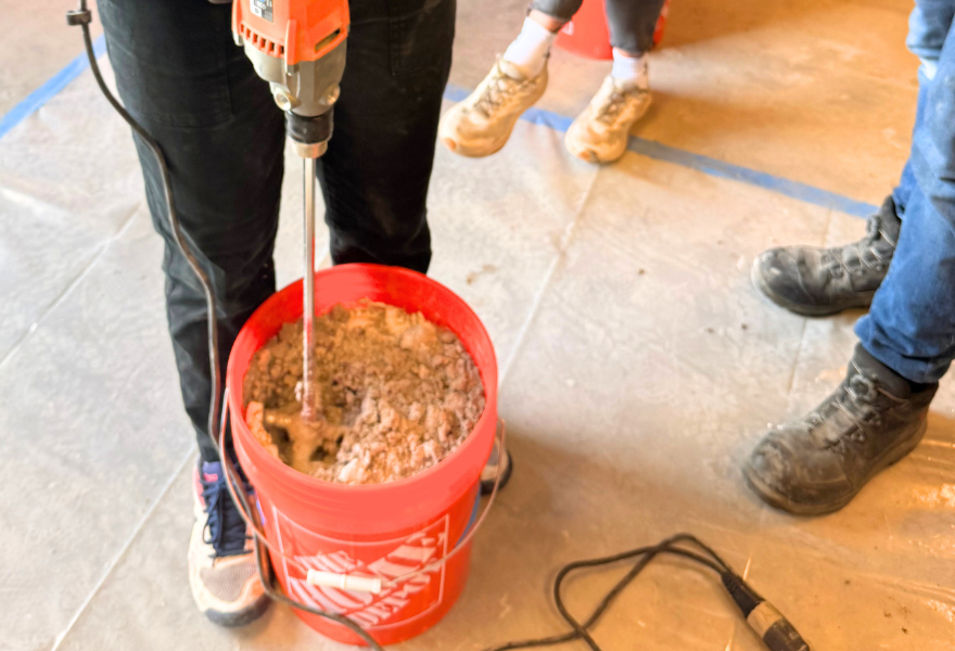 Students mixing concrete in bucket